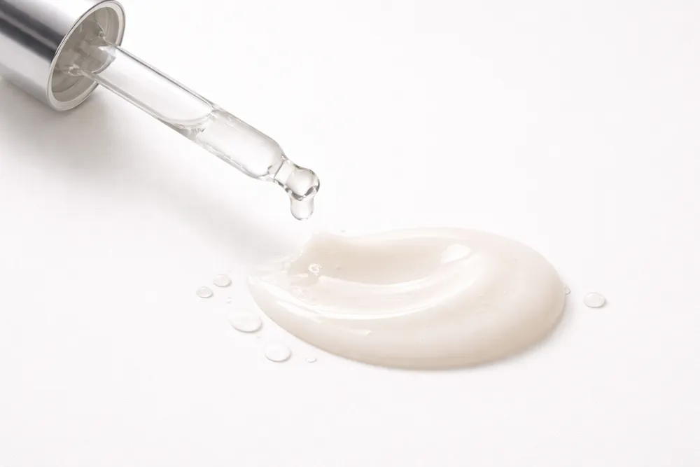 Textura de suero dermocosmético aplicada con pipeta sobre superficie limpia, representando activos cosméticos utilizados en el cuidado de la piel sensible.