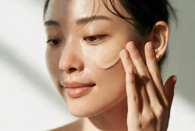 mujer asiática aplicando sérum de centella asiática sobre piel luminosa y saludable